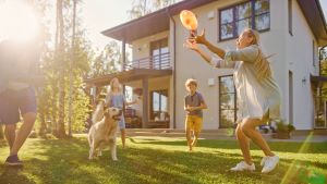 Family playing with dog in the backyard